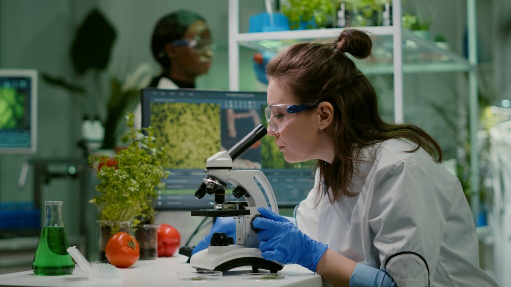 A imagem exibe uma cientista analisando as plantas em um botânicas